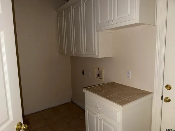 a kitchen with granite countertop white cabinets and a wooden floor