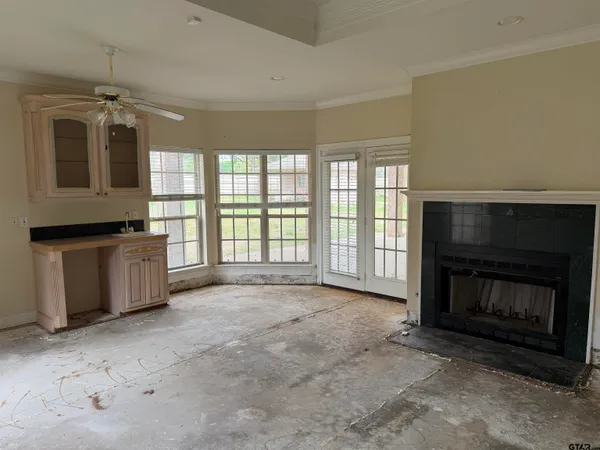 a view of an empty room with a fireplace and a window