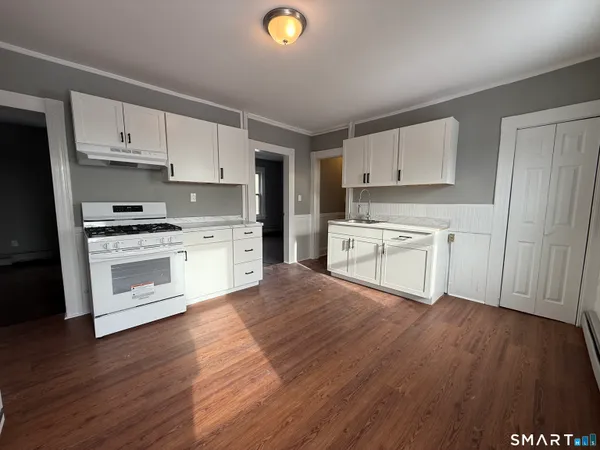 a kitchen with wooden floors and white appliances