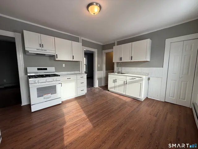 a kitchen with wooden floors and white appliances