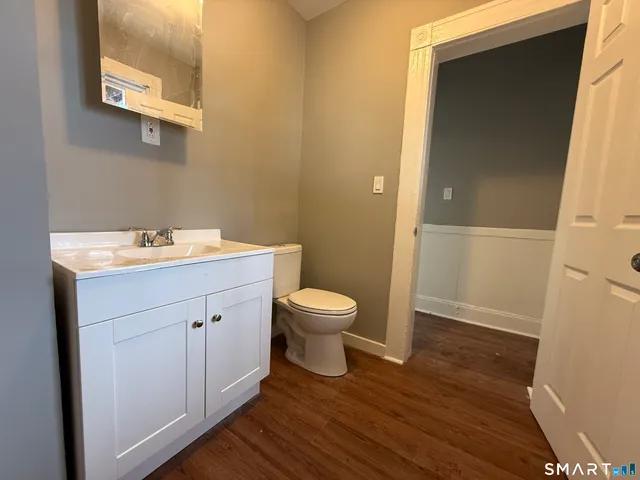 a bathroom with a toilet sink and mirror