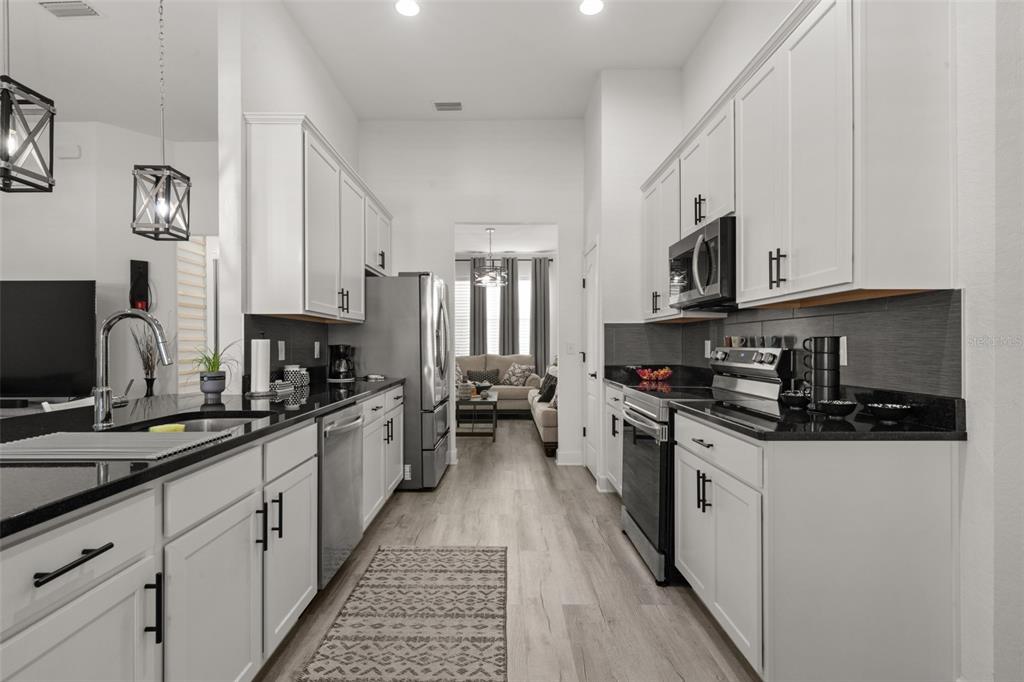 1113 Caloosa Ridge Way Babson Park, FL 33827 - Photo 34 of 77 a kitchen with stainless steel appliances a sink stove top oven and cabinets