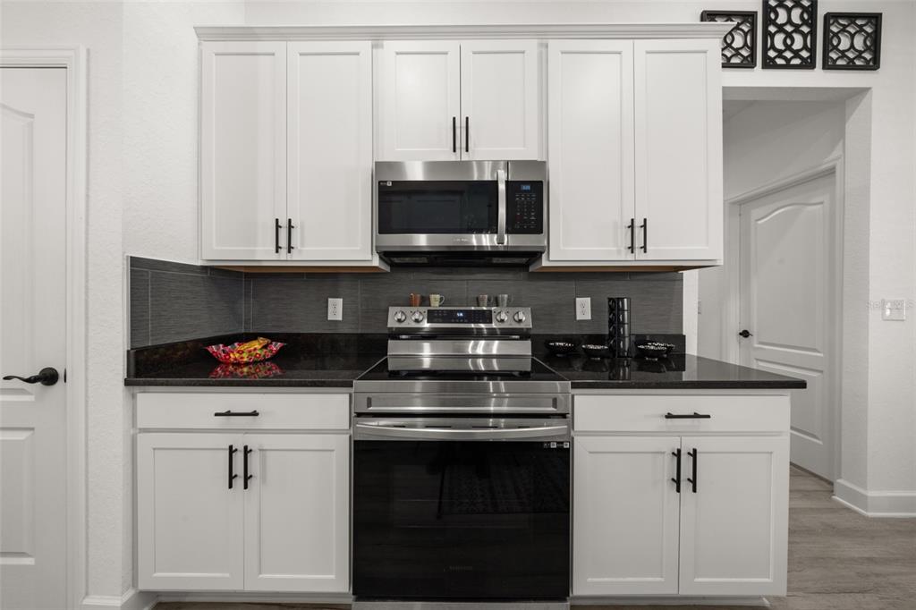 1113 Caloosa Ridge Way Babson Park, FL 33827 - Photo 37 of 77 a kitchen with white cabinets and appliances
