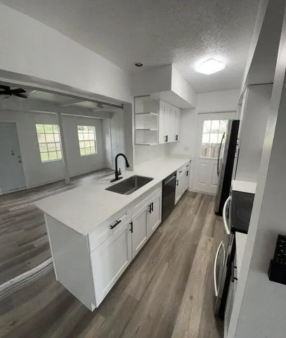 a large white kitchen with sink refrigerator and window