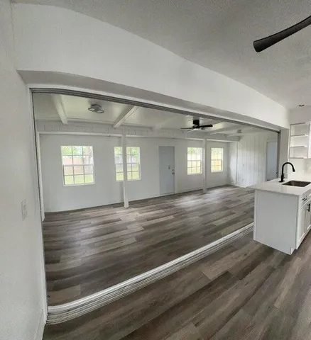 a view hallway and an empty room with wooden floor