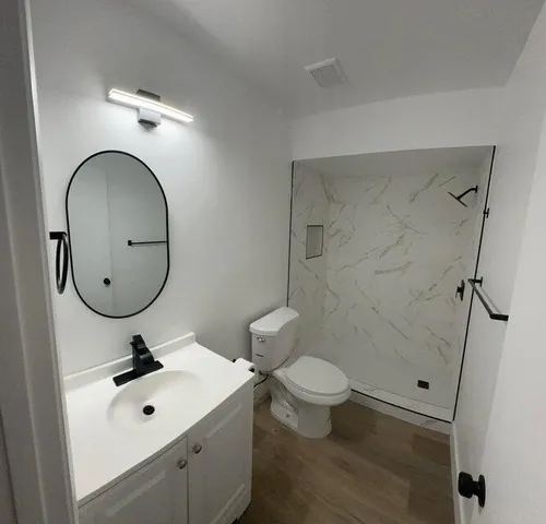 a bathroom with a sink a toilet and a mirror
