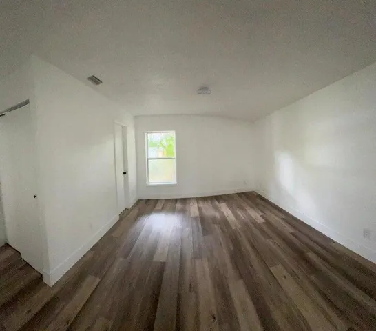 a view of an empty room and wooden floor