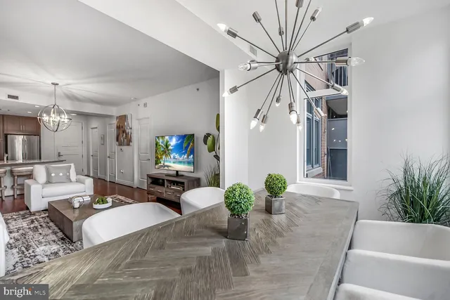 a living room with furniture a chandelier and a potted plant