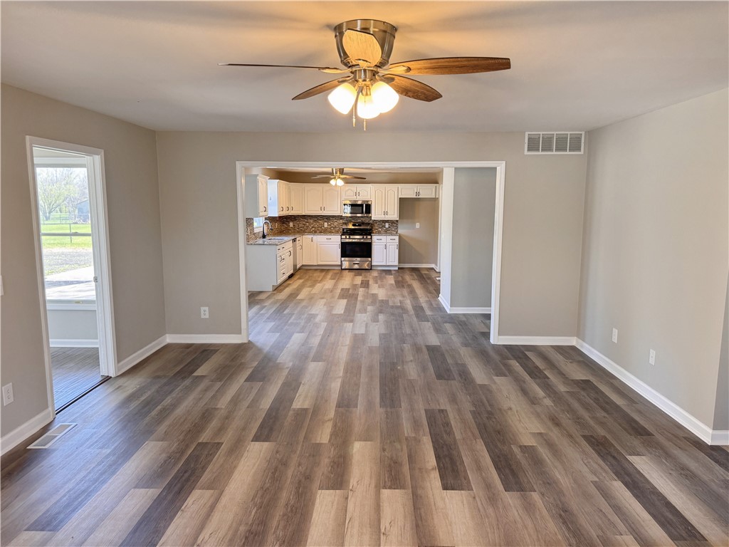 1118 Wedgewood Court Decatur, IL 62526 - Photo 10 of 22 a view of a room with wooden floor a ceiling fan and windows