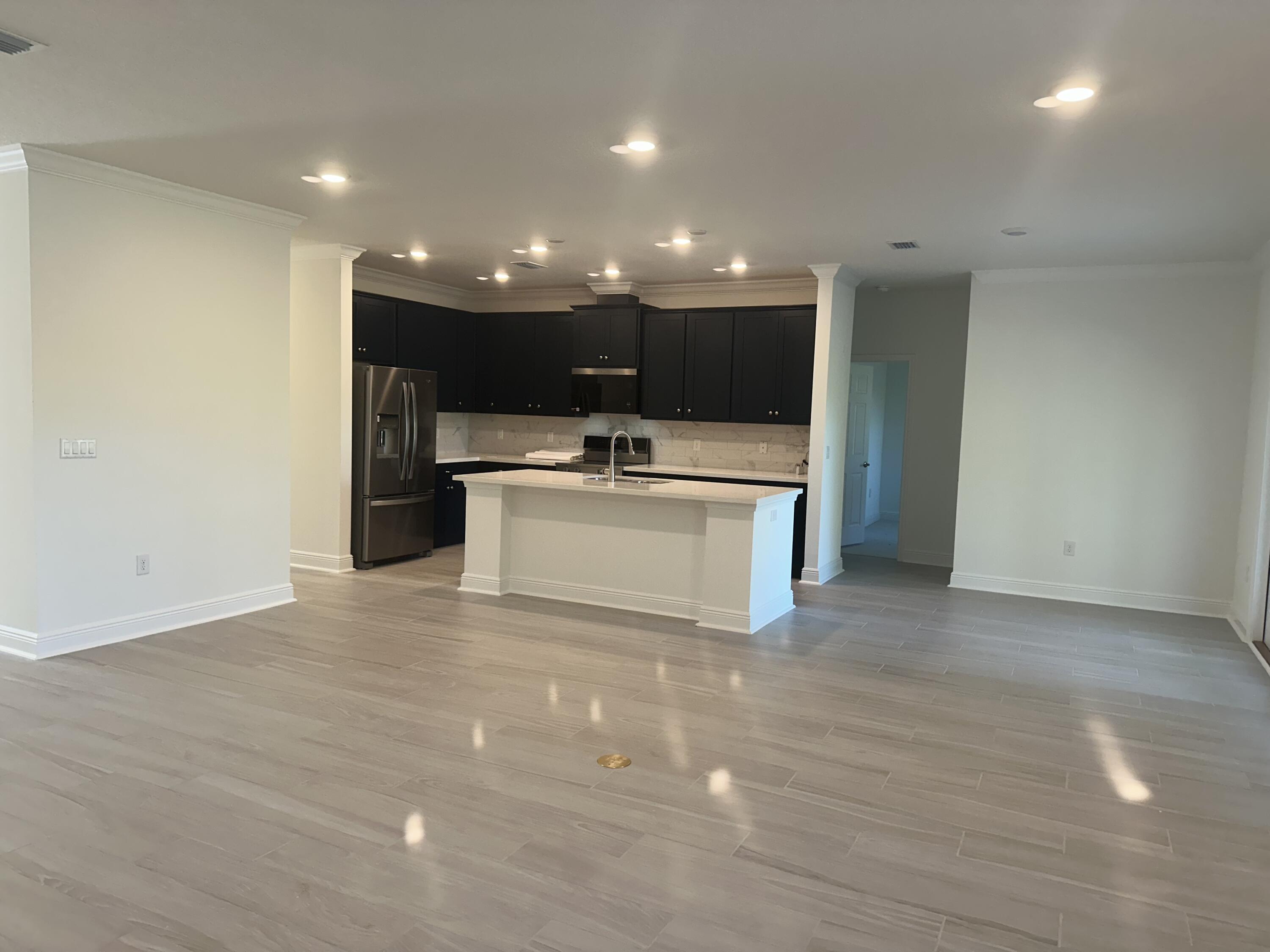 144 Bentgrass Road South Freeport, FL 32439 - Photo 3 of 8 a view of kitchen with kitchen island a sink wooden floor and a refrigerator