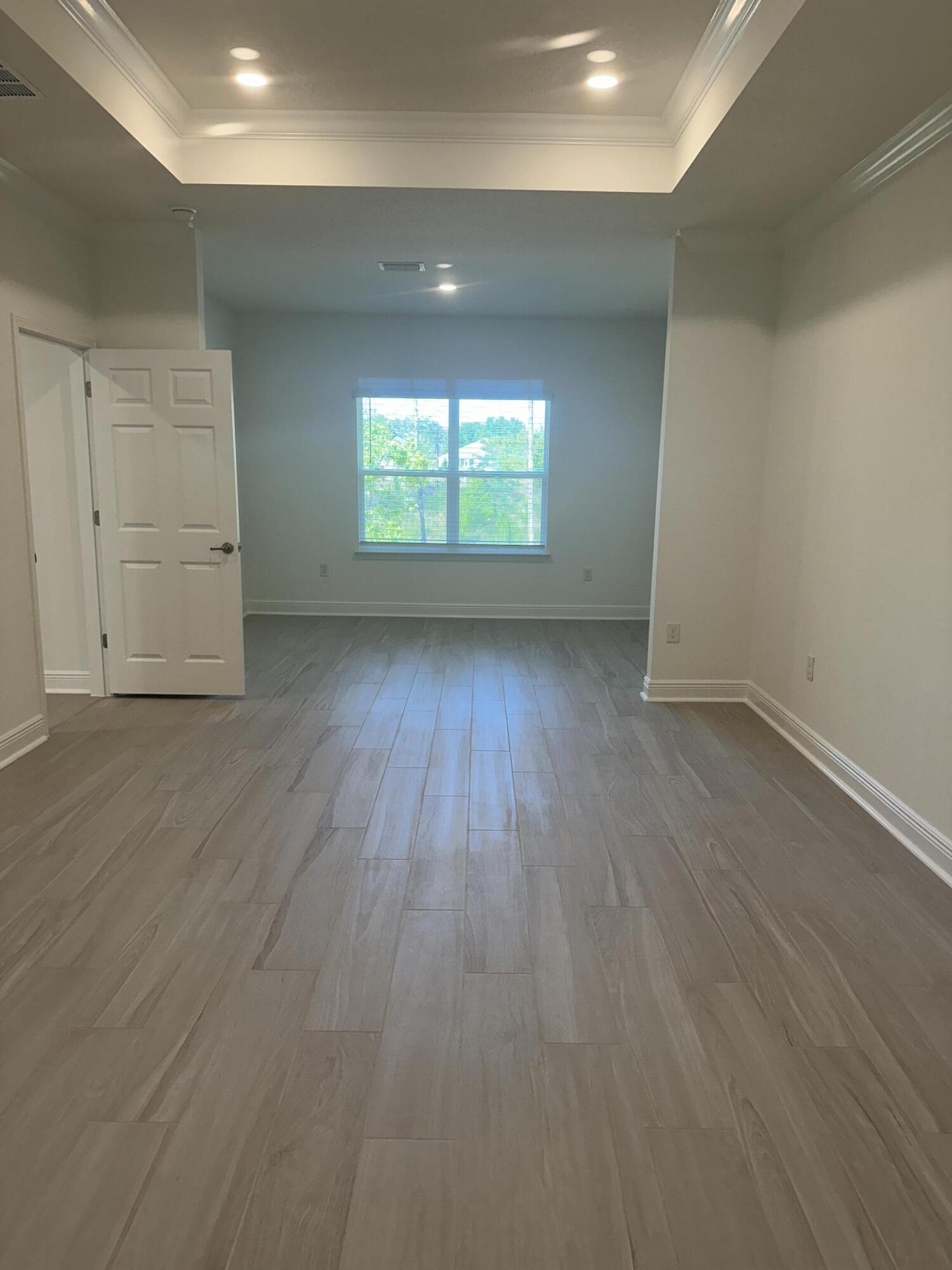 144 Bentgrass Road South Freeport, FL 32439 - Photo 4 of 8 an empty room with wooden floor and windows
