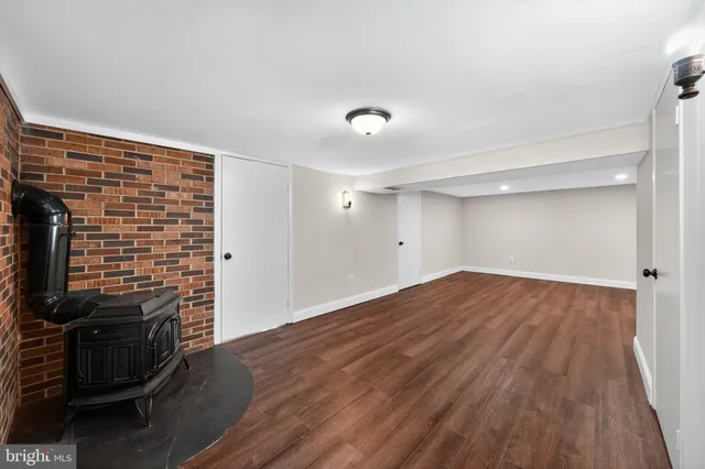 a view of empty room with wooden floor and fireplace