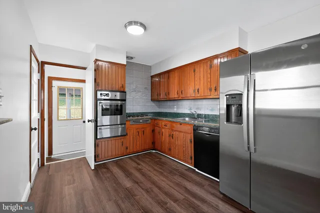 a kitchen with stainless steel appliances granite countertop a refrigerator and a stove top oven