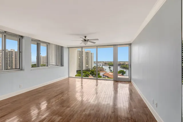 a view of an empty room with a window and wooden floor