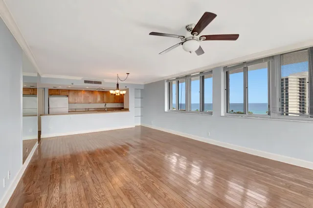 a view of empty room with wooden floor and ceiling fan