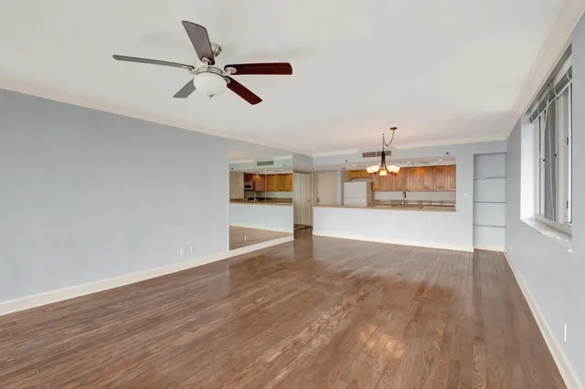 a view of a room with wooden floor and chandelier