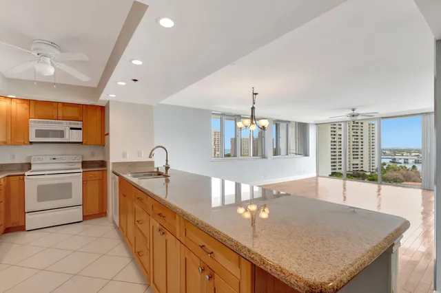 a living room with furniture floor to ceiling window and wooden floor
