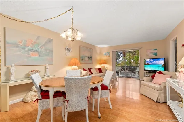 a view of a dining room with furniture a chandelier and wooden floor