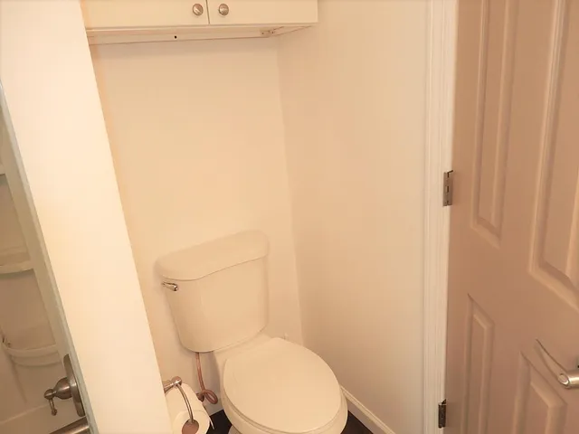 a white toilet sitting next to a shower
