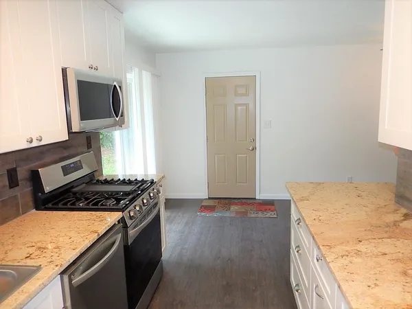 a kitchen with granite countertop a stove and a sink