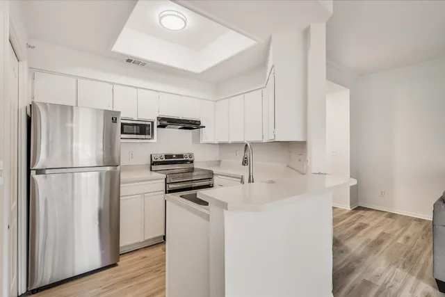 a kitchen with stainless steel appliances a refrigerator sink and microwave