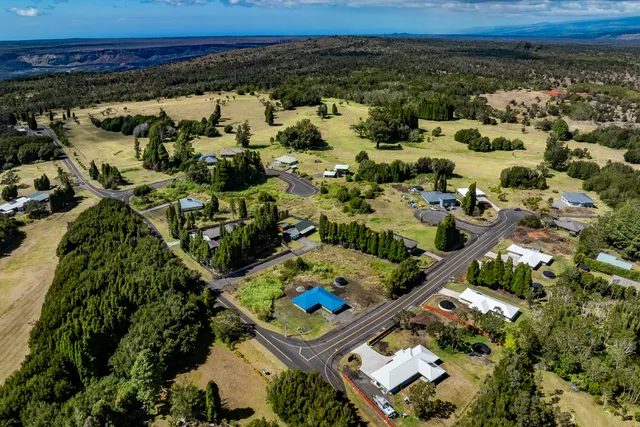 an aerial view of a residential houses with a yard