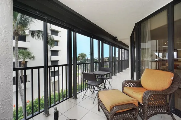 a living room with furniture a flat screen tv and a large window