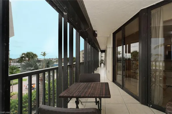 a living room with furniture a wooden floor and a kitchen view