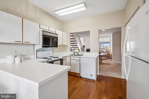 a living room with stainless steel appliances a refrigerator a couch and a view of living room