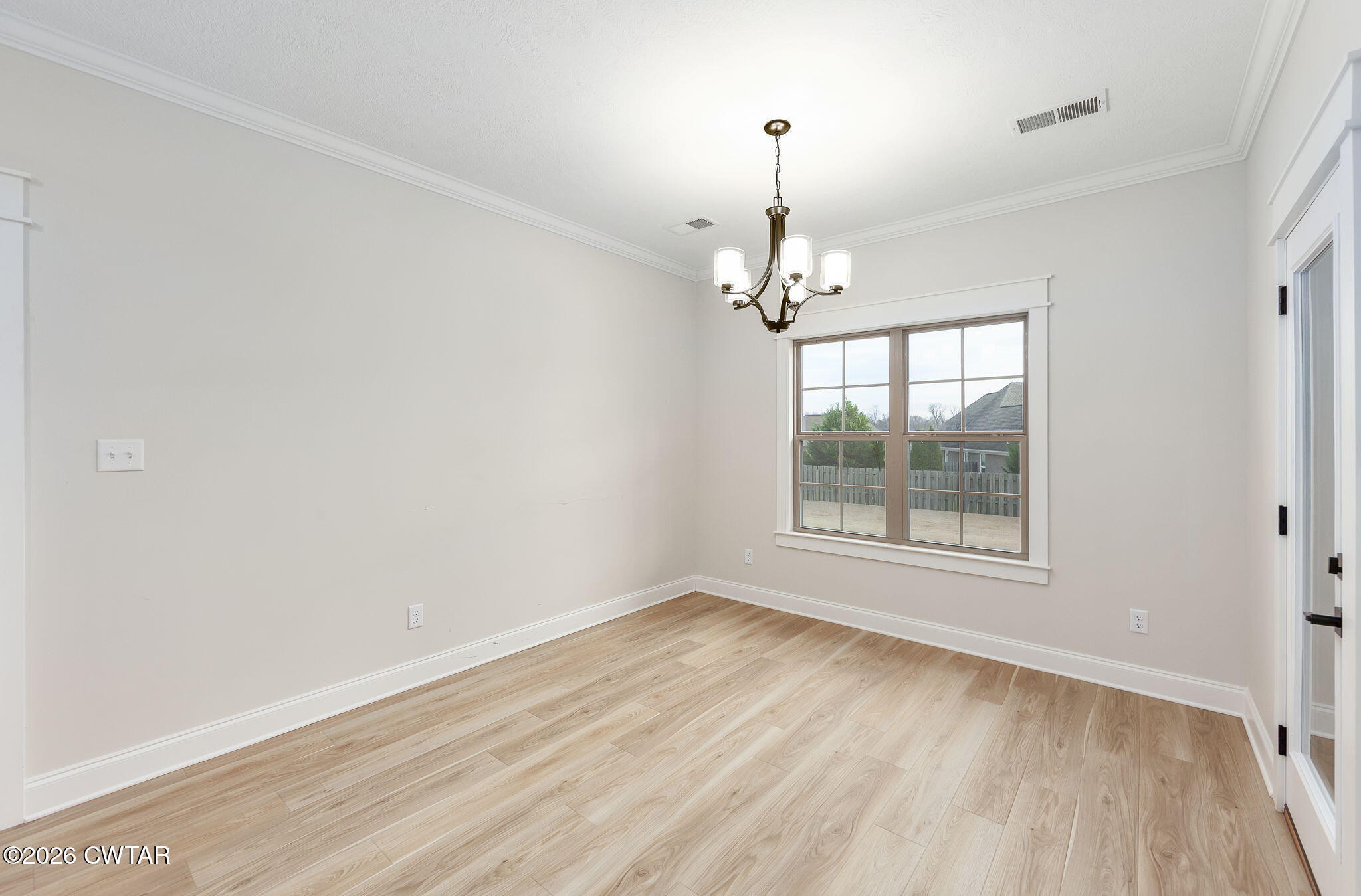126 Isaiah Drive Jackson, TN 38305 - Photo 10 of 32 a view of an empty room with wooden floor and a window