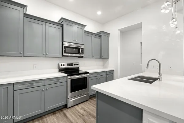 a kitchen with stainless steel appliances granite countertop a sink a stove and a refrigerator