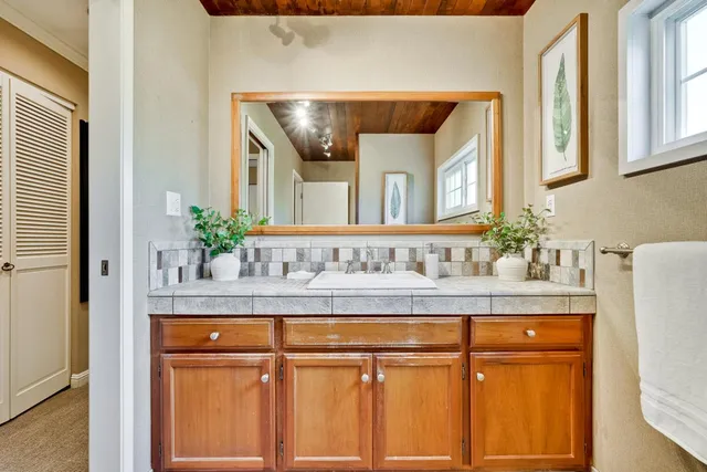 a bathroom with a granite countertop sink and a mirror