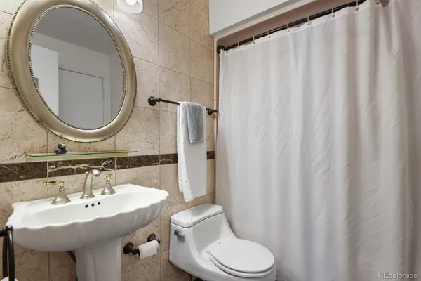a bathroom with a sink a toilet and a mirror