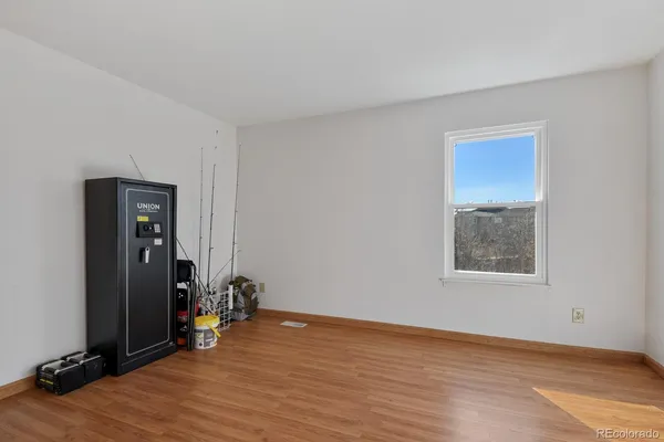 a view of a room with wooden floor and a ceiling fan