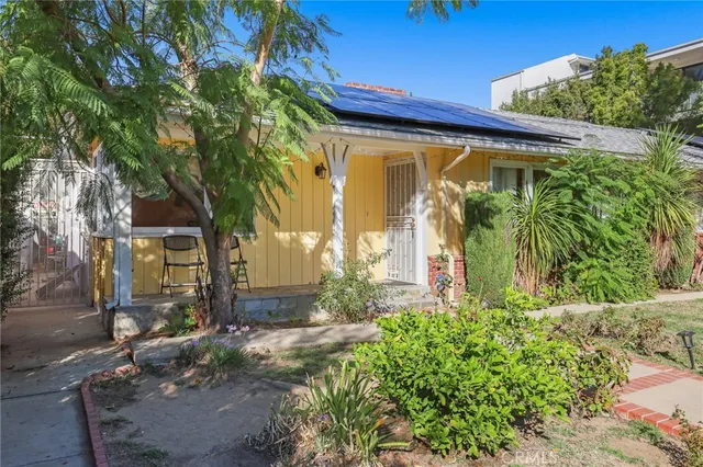a view of a house with a tree and plants