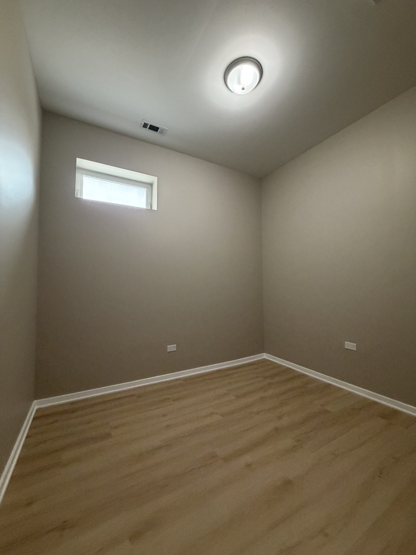 22 North Pulaski Road, Unit 1R Chicago, IL 60624 - Photo 20 of 22 a view of an empty room with wooden floor and a window