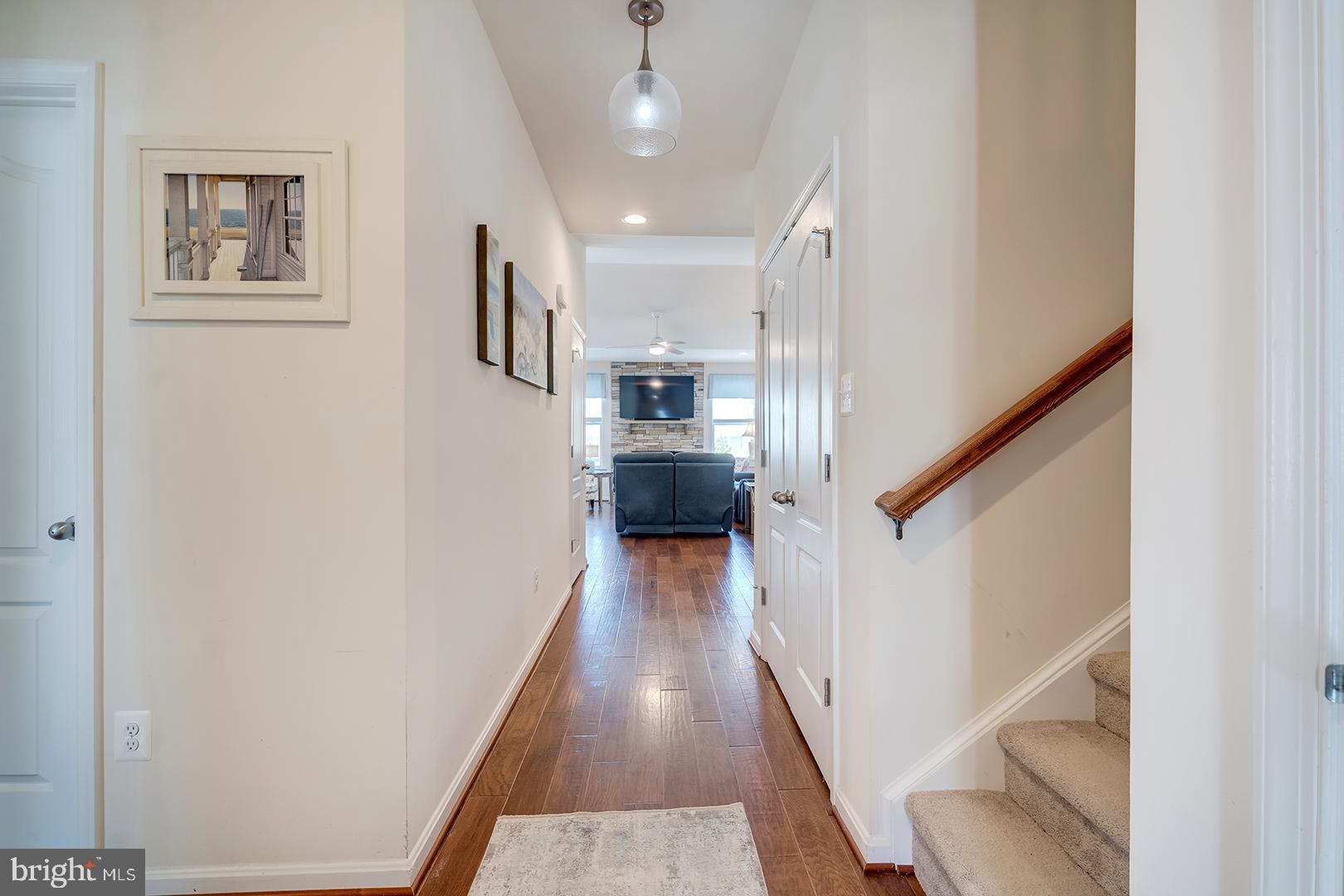 34438 Spring Brook Avenue Lewes, DE 19958 - Photo 9 of 58 a view of a hallway with wooden floor and staircase