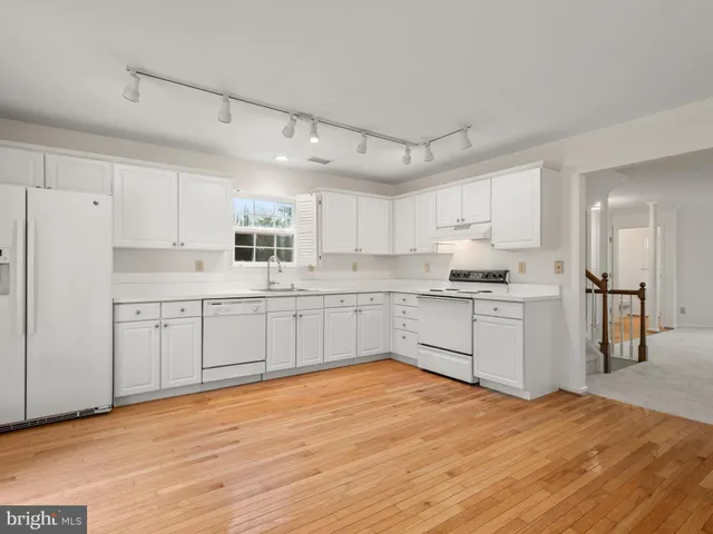 a kitchen with cabinets wooden floor and a sink