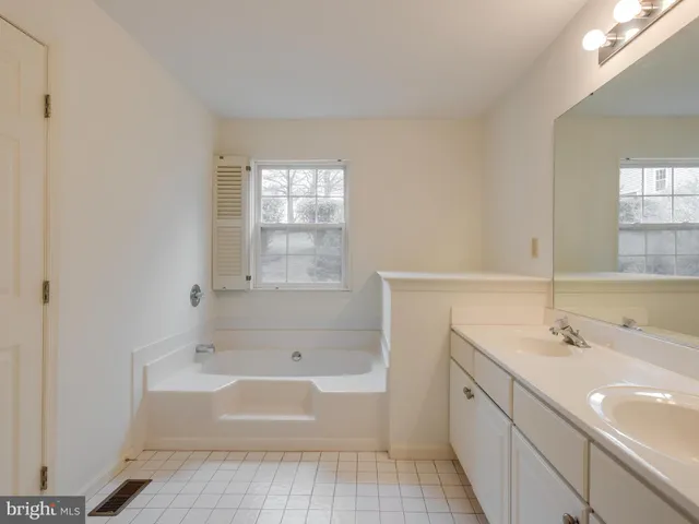 a spacious bathroom with a double vanity sink toilet and a mirror