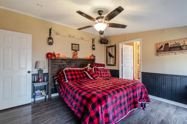 a bedroom with a bed and a flat tv screen on dresser