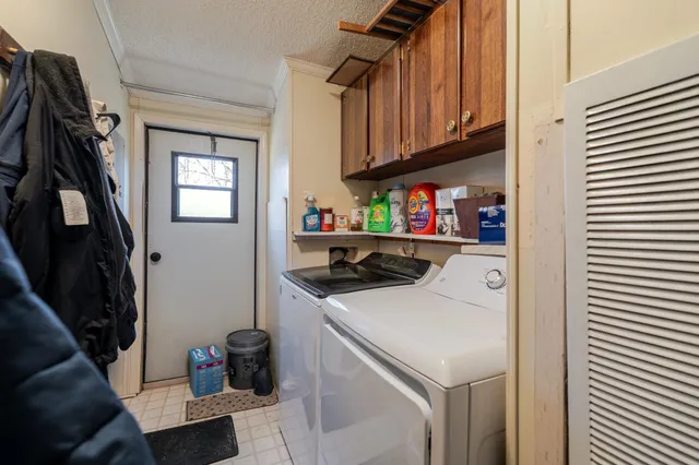 a front view of a house with a yard outdoor seating and covered with trees