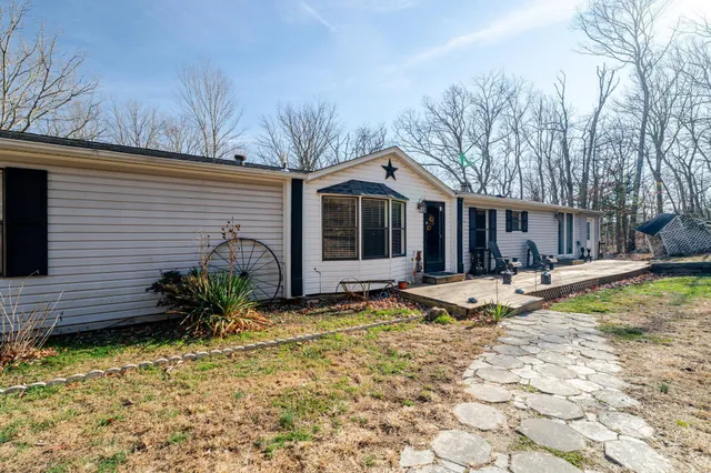 a view of dirt field with trees in the background