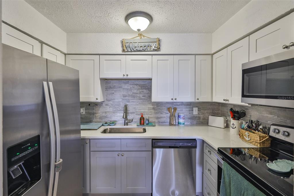 1041 Apollo Beach Boulevard, Unit F Apollo Beach, FL 33572 - Photo 18 of 35 a kitchen with stainless steel appliances a sink stove and refrigerator