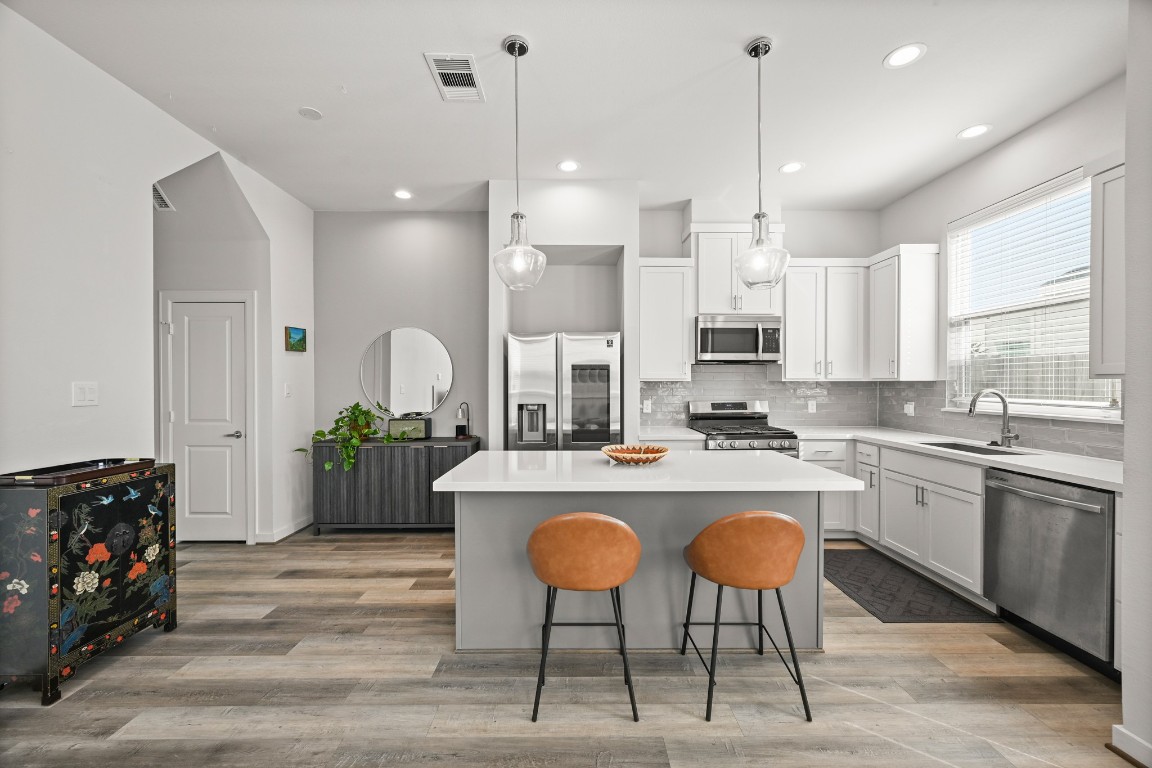 4002 Elser Street Houston, TX 77009 - Photo 2 of 36 a large kitchen with kitchen island granite countertop a counter space a sink appliances and cabinets