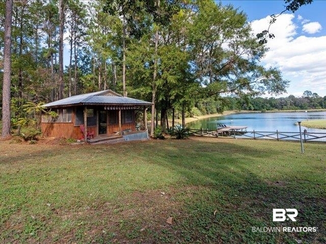 4650 Wiggins Lane Wilmer, AL 36587 - Photo 55 of 66 View of grassy yard featuring a water view and a boat dock