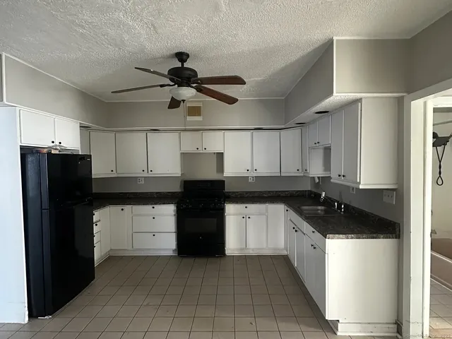 a kitchen with granite countertop a refrigerator and a sink