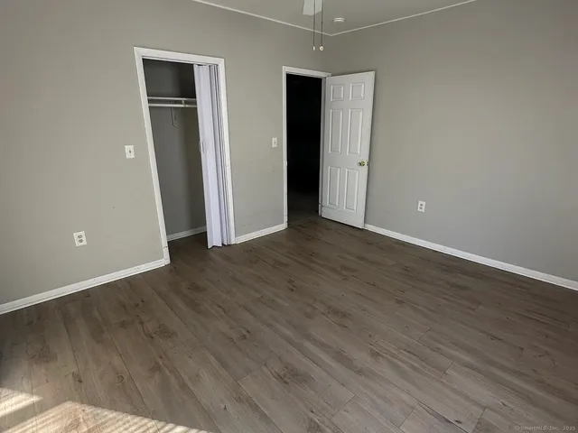 an empty room with wooden floor and closet