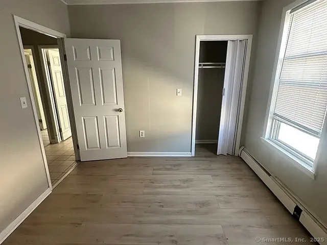 an empty room with windows and closet area