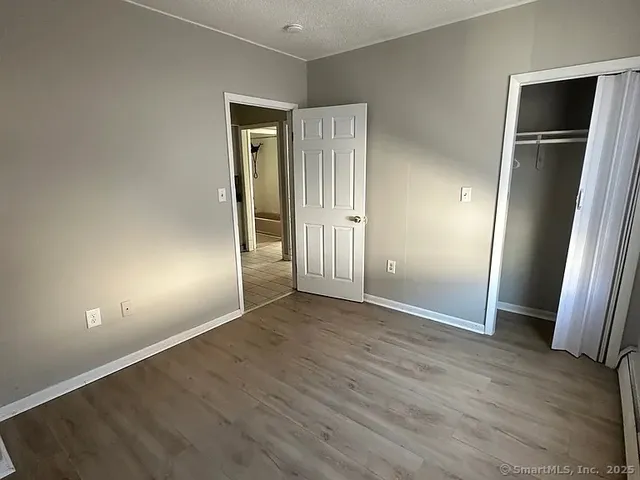 an empty room with wooden floor and closet