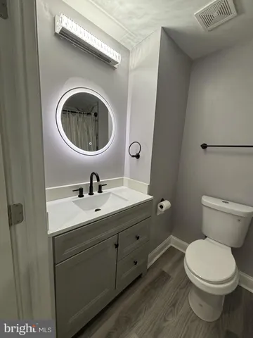 a bathroom with a toilet a sink and mirror